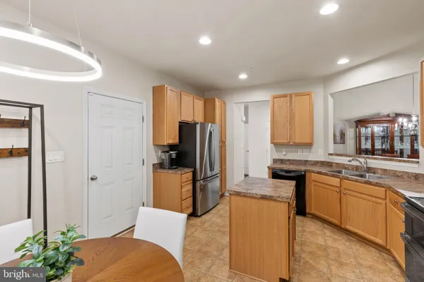 a kitchen with stainless steel appliances granite countertop a stove a sink dishwasher and a microwave oven with white cabinets