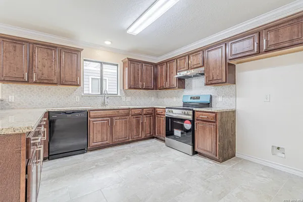 a kitchen with stainless steel appliances granite countertop wooden cabinets a sink and dishwasher a stove with wooden floors