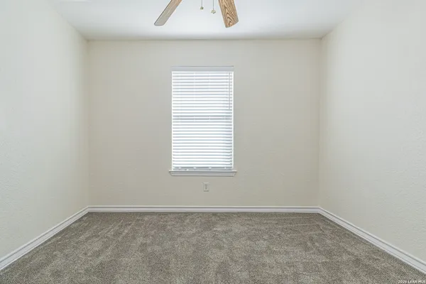 an empty room with a chandelier fan