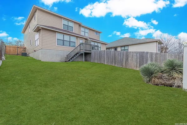 a view of a yard in front of a brick house with large windows
