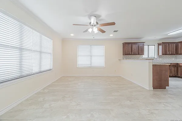 a view of a kitchen with kitchen island a sink appliances and a cabinets