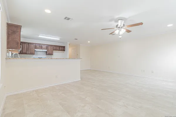 an empty room with window and ceiling fan