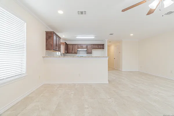 an empty room with a ceiling fan and a window