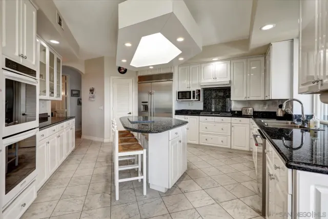 a kitchen with stainless steel appliances granite countertop a stove top oven a sink a counter space and cabinets