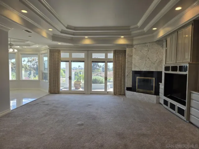 a view of an empty room with a fireplace and a window