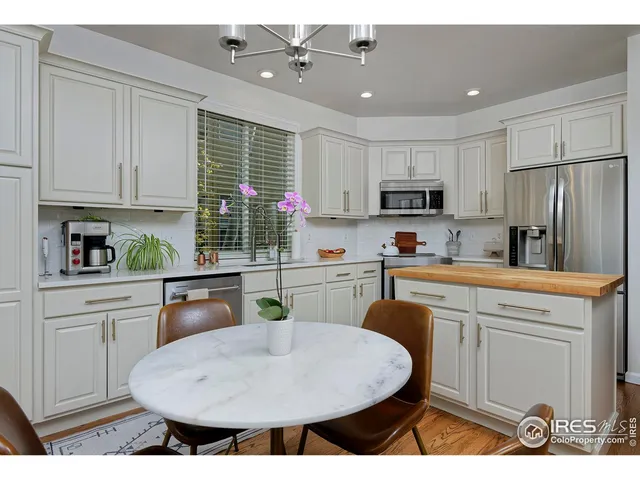 a dining room with furniture a chandelier and wooden floor