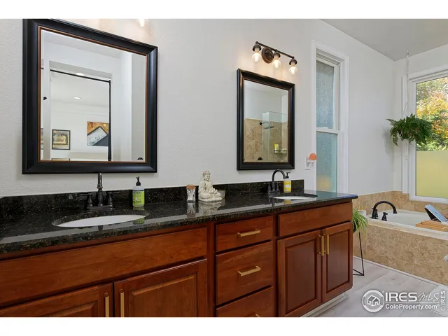 a bathroom with a granite countertop sink a mirror and shower