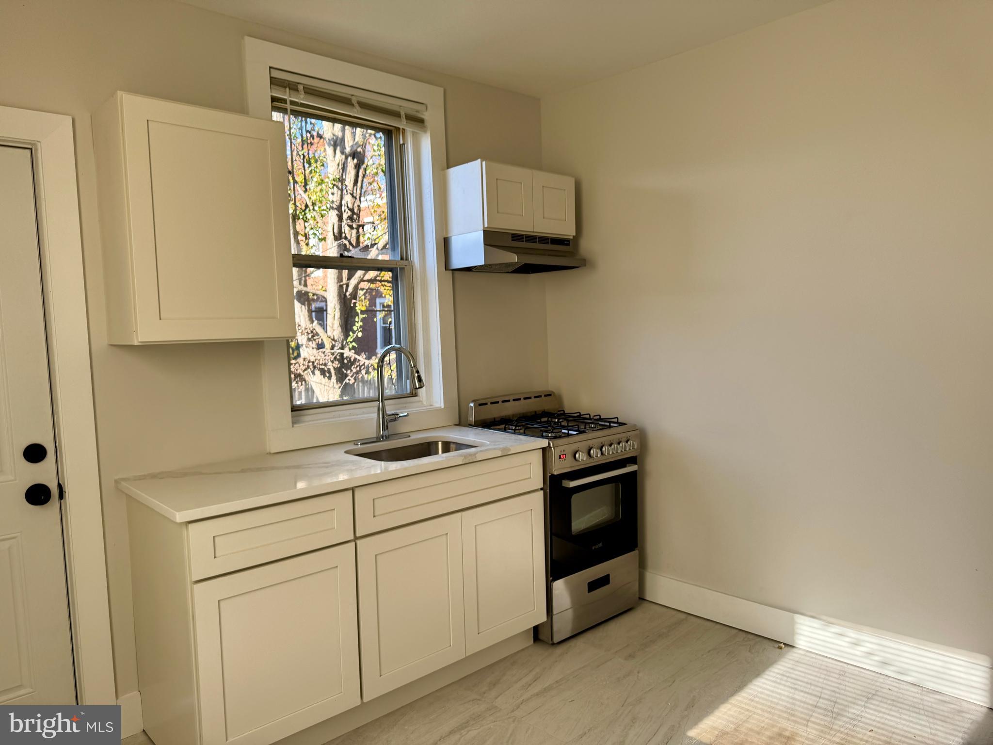 6308 North Lambert Street Philadelphia, PA 19138 - Photo 8 of 21 a utility room with a stove a sink and a window