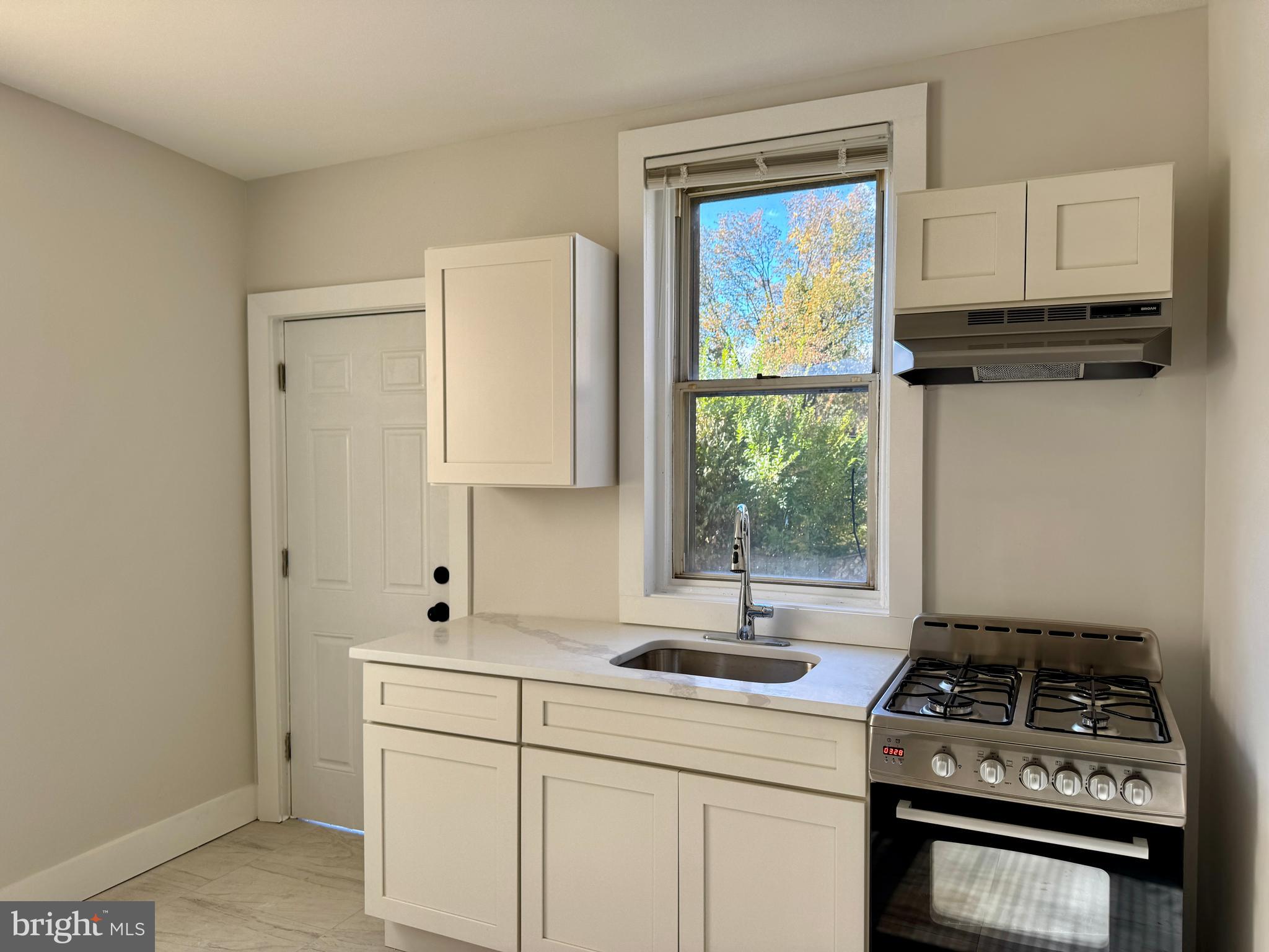6308 North Lambert Street Philadelphia, PA 19138 - Photo 10 of 21 a kitchen with a stove a sink and a window