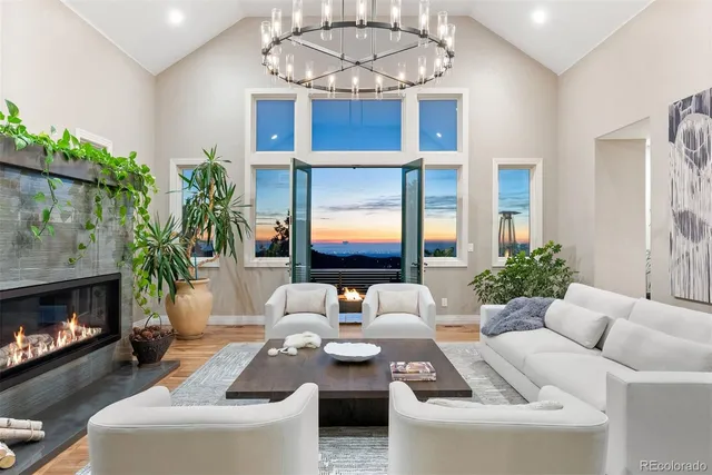 a living room with furniture a chandelier and a fireplace