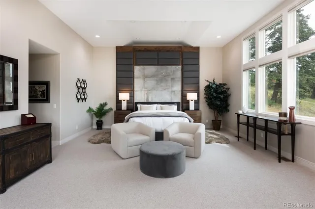 a bedroom with a bed a flat screen tv and a fireplace