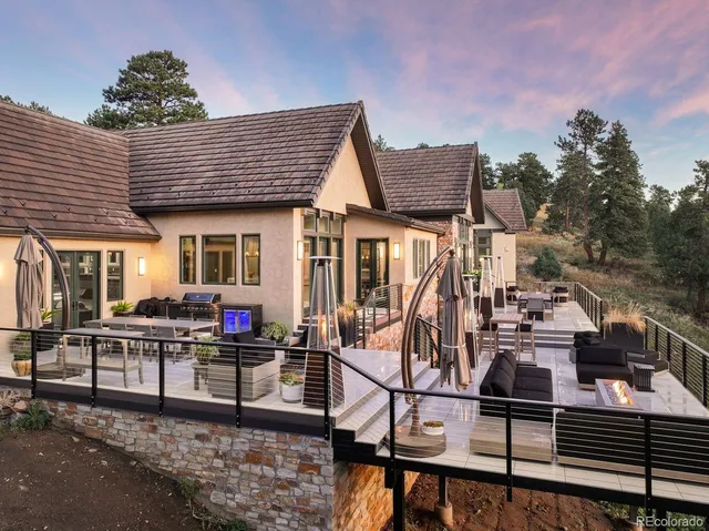 a view of a patio with a dining table and chairs with potted plants