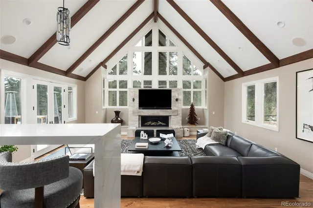 a living room with furniture a flat screen tv and a floor to ceiling window