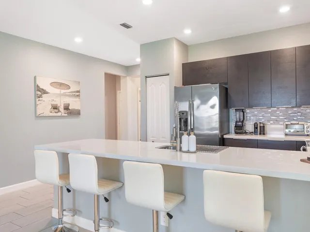 a kitchen with granite countertop white cabinets and chairs