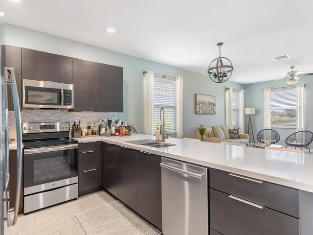 a kitchen with stainless steel appliances granite countertop a sink and dishwasher a stove top oven with wooden floor