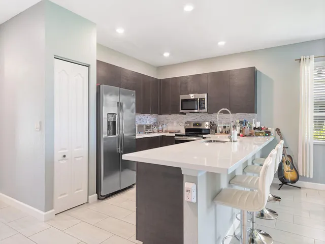 a kitchen with stainless steel appliances a refrigerator sink and microwave