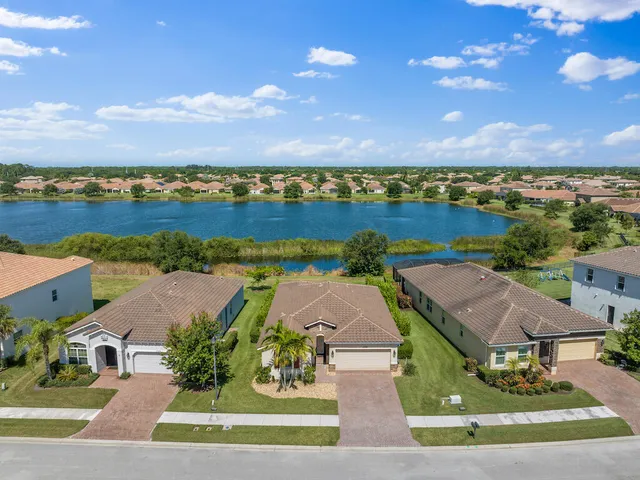 an aerial view of residential houses with outdoor space and ocean view
