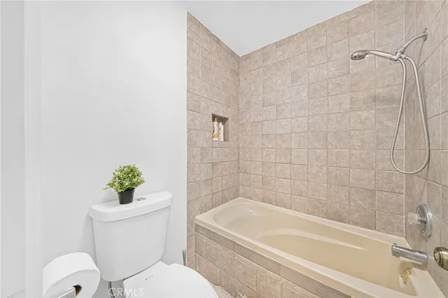 a white toilet sitting next to a bath tub