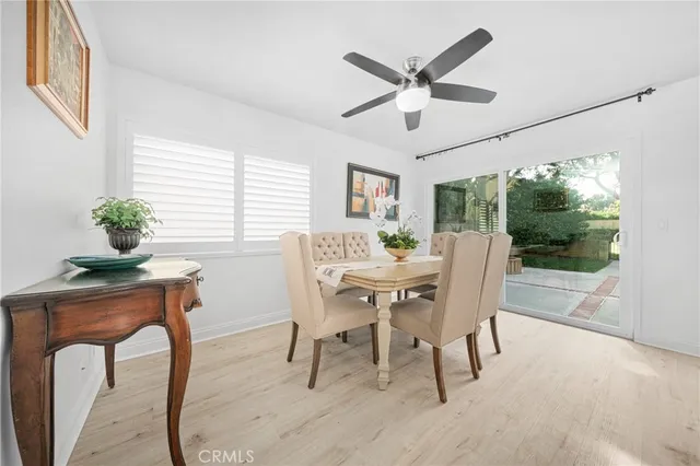 a dining room with furniture a potted plant and a large window