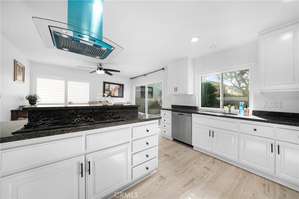 60 Willow Tree Lane Irvine, CA 92612 - Photo 7 of 32 a large white kitchen with granite countertop a sink a window and stainless steel appliances