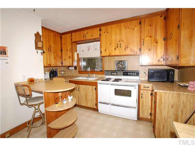 4317 Kerley Road Durham, NC 27705 - Photo 10 of 25 The Kitchen Area has a Breakfast Bar for Two, 40 inch Electric Stove, Nice Counter Space & Window over the Kitchen Sink.