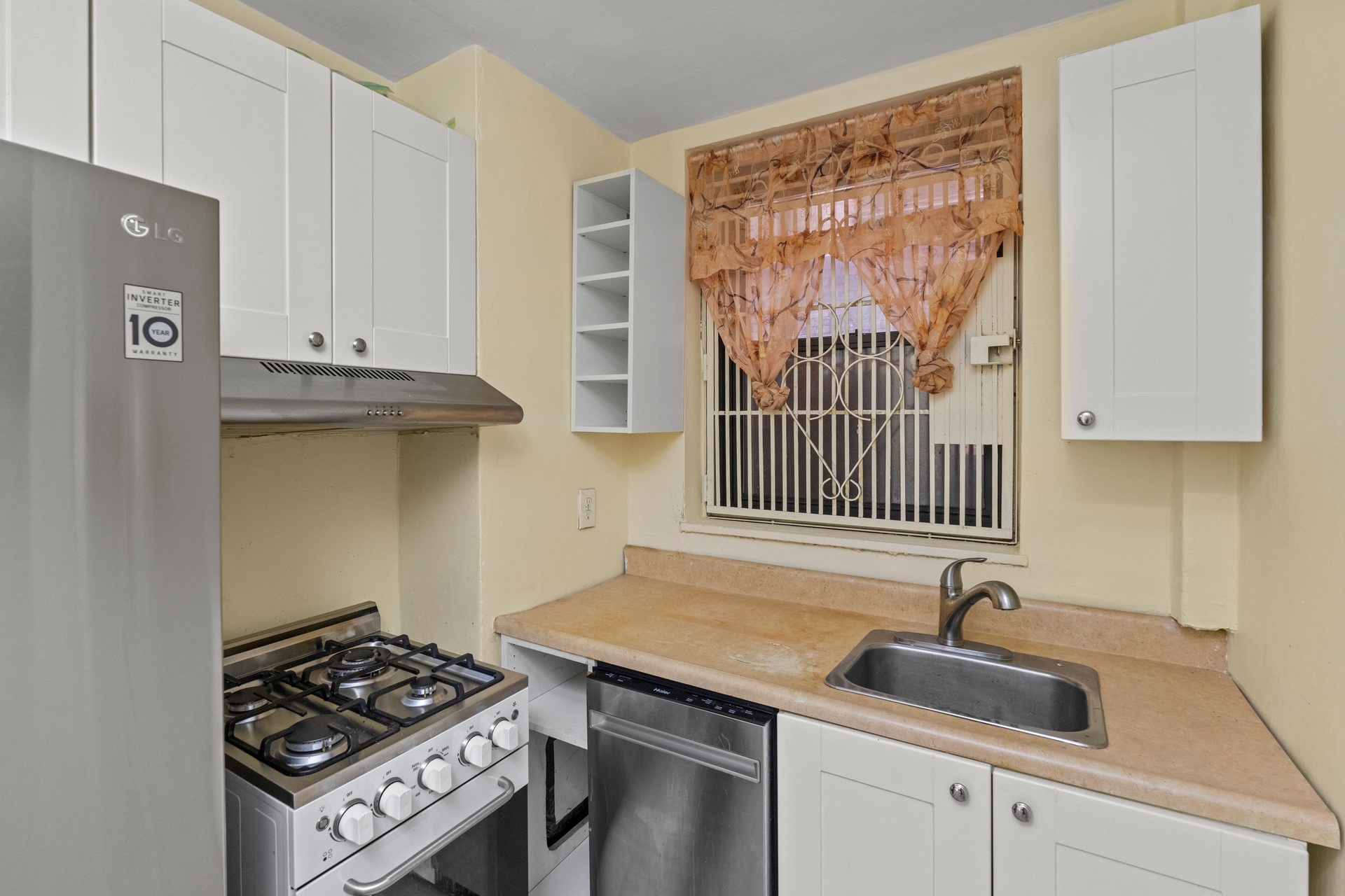 135 West 58th Street, Unit 1C Manhattan, NY 10019 - Photo 7 of 9 a kitchen with granite countertop a sink stove and cabinets