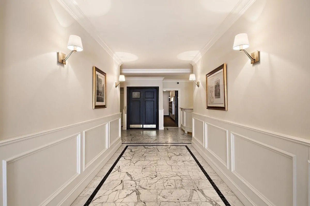 135 West 58th Street, Unit 1C Manhattan, NY 10019 - Photo 8 of 9 a hallway with white doors wooden floor and front door