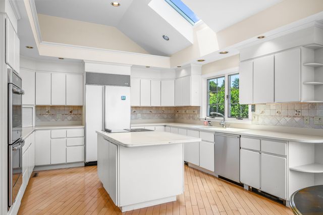 a kitchen with a sink a stove a refrigerator and white cabinets
