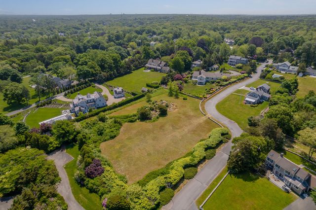 a view of a house with a big yard and large trees