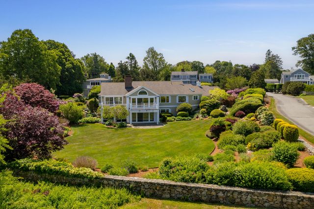 a view of a house with a big yard plants and large trees