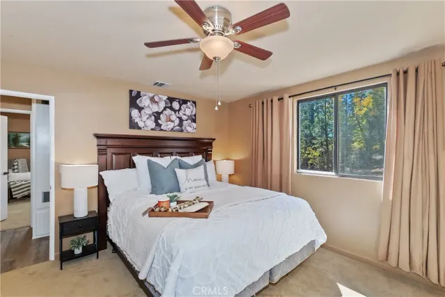 a bed sitting in a bedroom next to a window with lamp