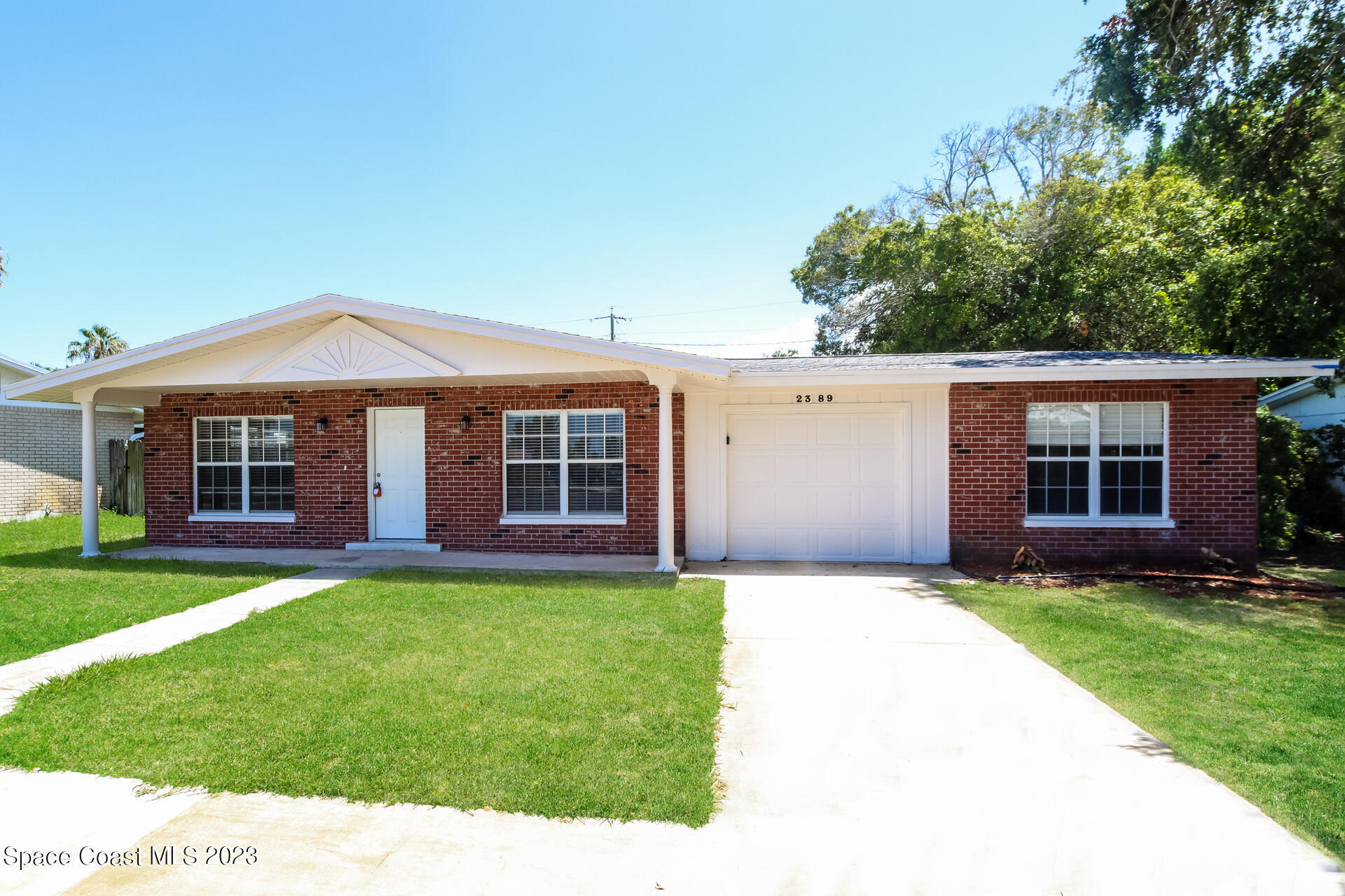 2389 Ricky Road Melbourne, FL 32935 - Photo 2 of 16 a front view of a house with a yard and garage
