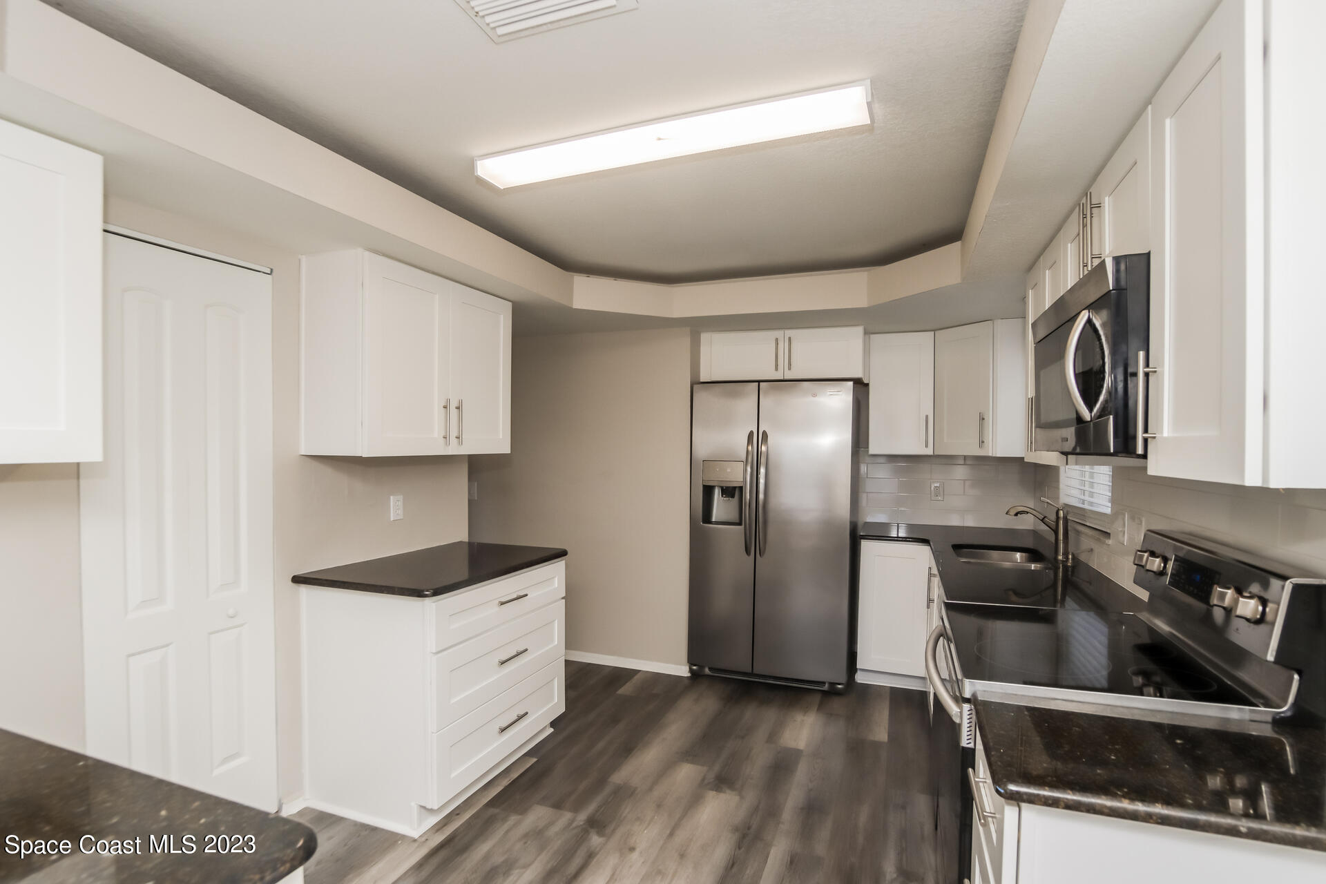 2389 Ricky Road Melbourne, FL 32935 - Photo 5 of 16 a kitchen with stainless steel appliances a refrigerator sink and stove