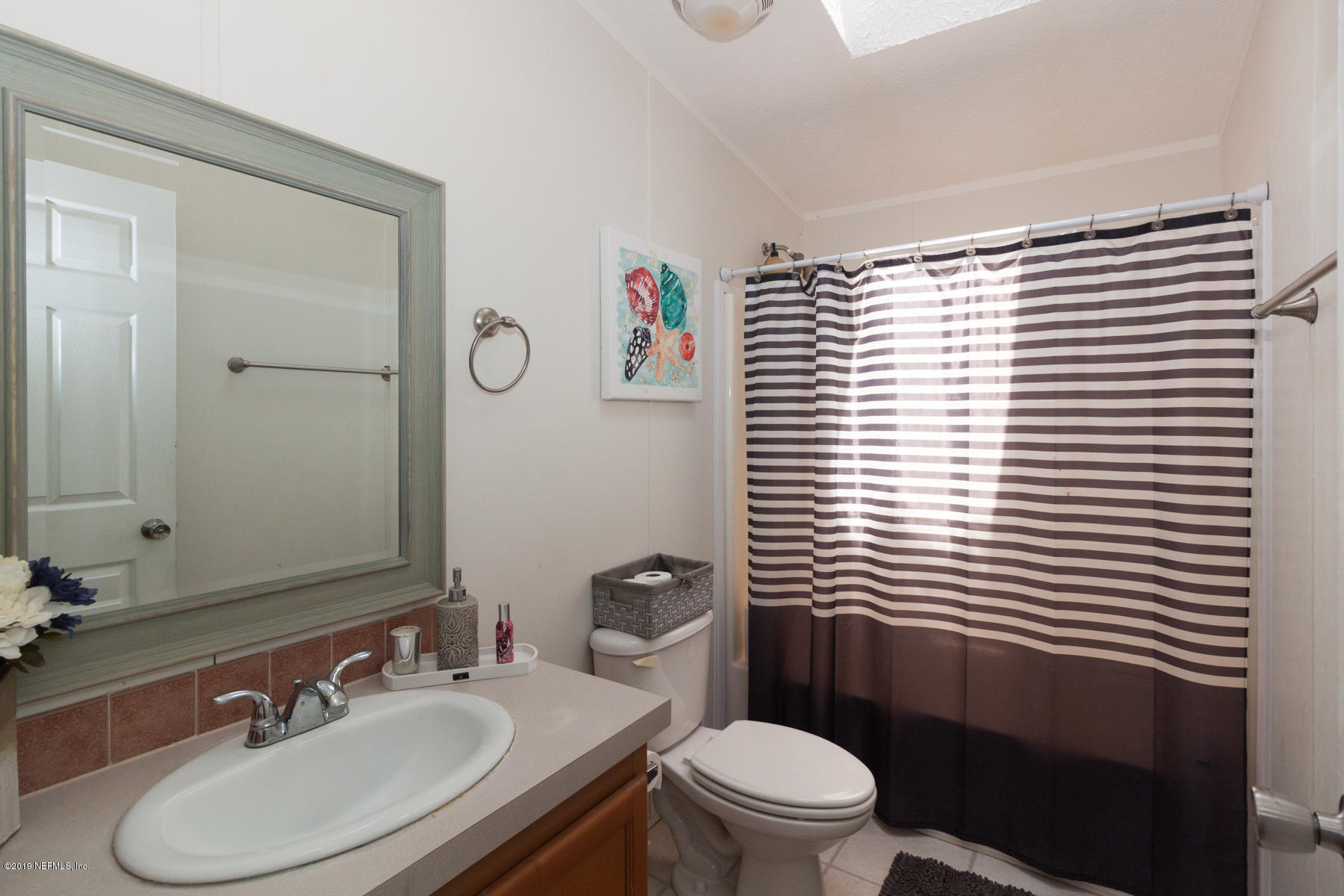55154 Spencerville Road Callahan, FL 32011 - Photo 18 of 23 a bathroom with a sink a toilet and mirror