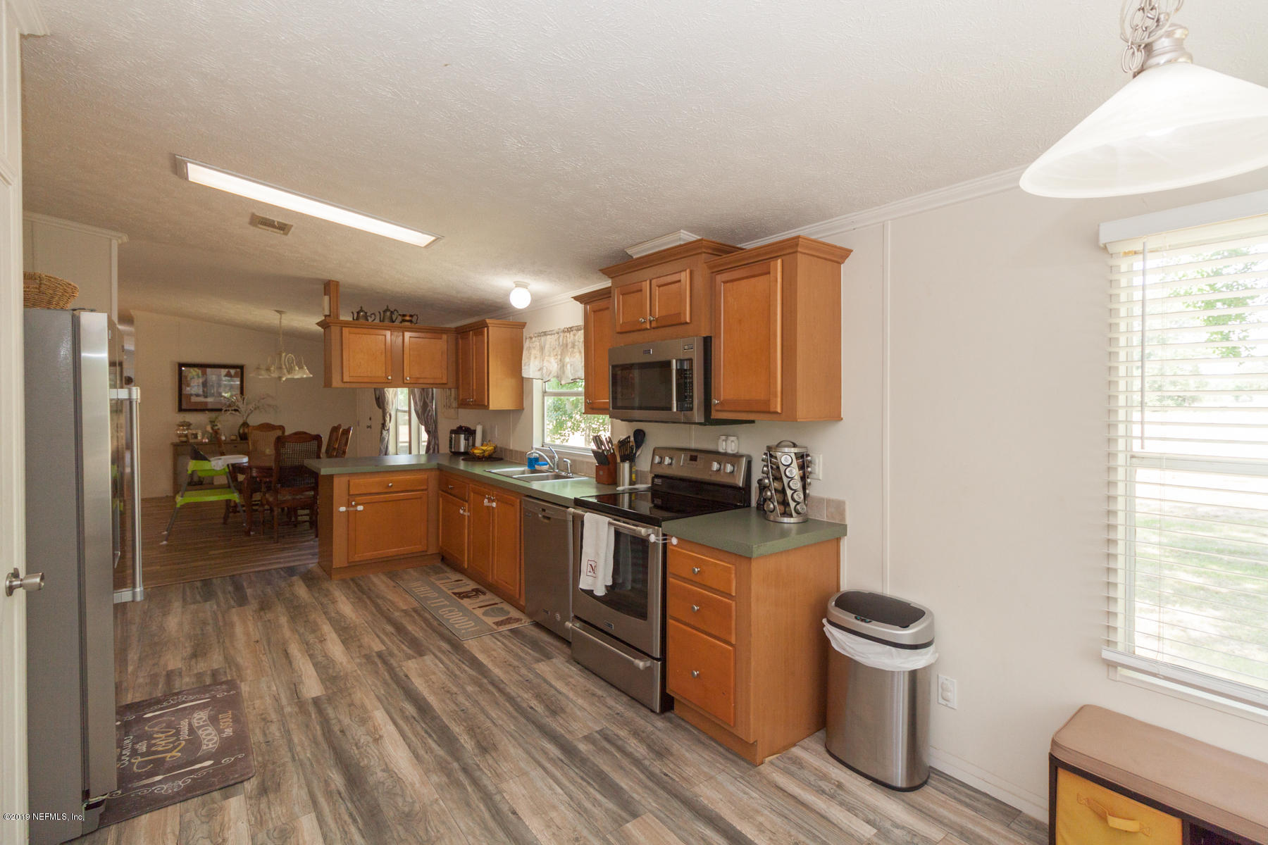 55154 Spencerville Road Callahan, FL 32011 - Photo 7 of 23 a kitchen with sink cabinets and wooden floor