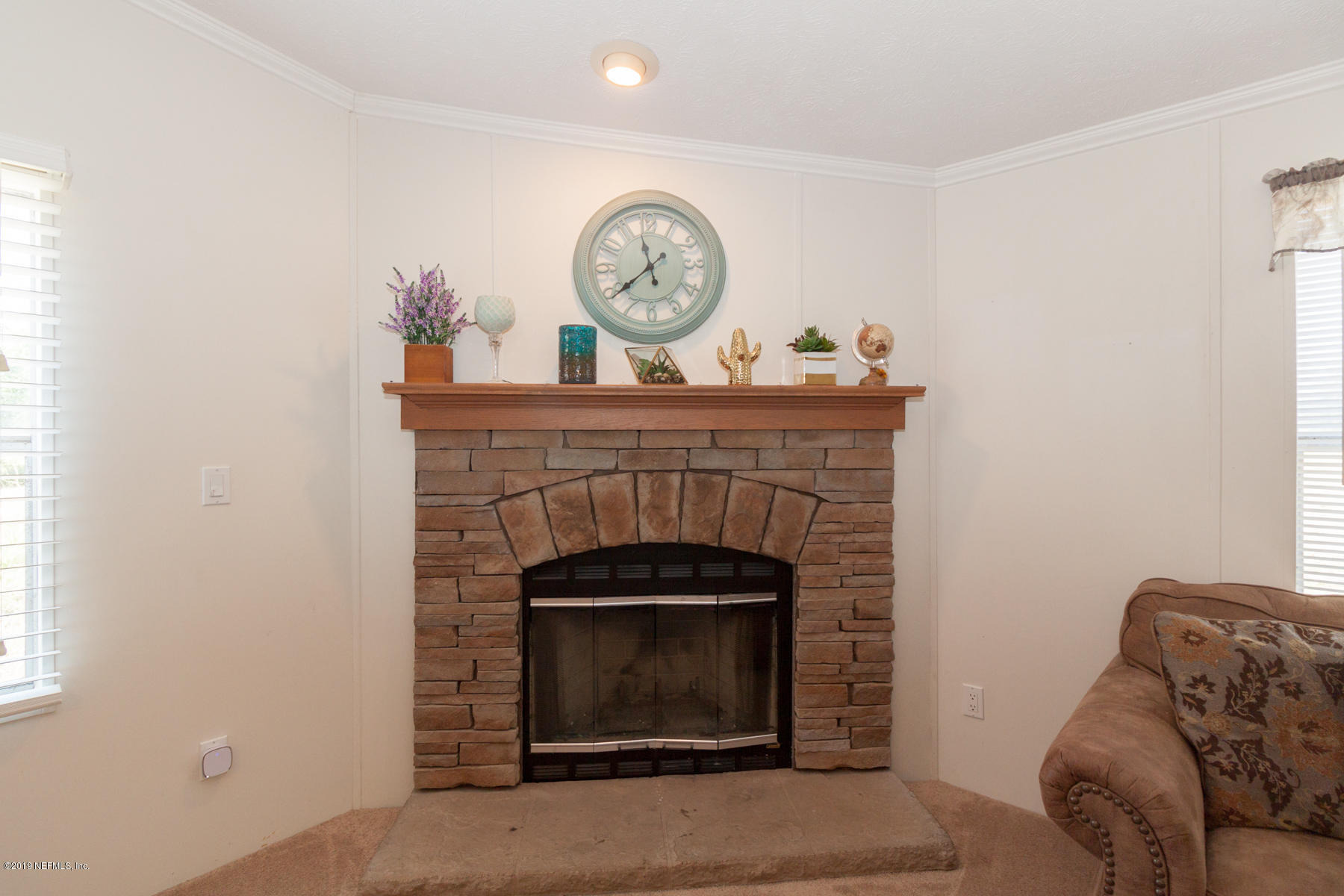 55154 Spencerville Road Callahan, FL 32011 - Photo 9 of 23 a living room with furniture a clock and a fireplace