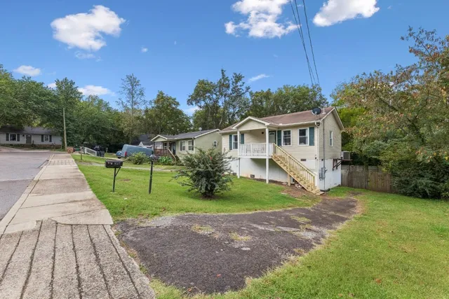 a front view of a house with a yard and trees