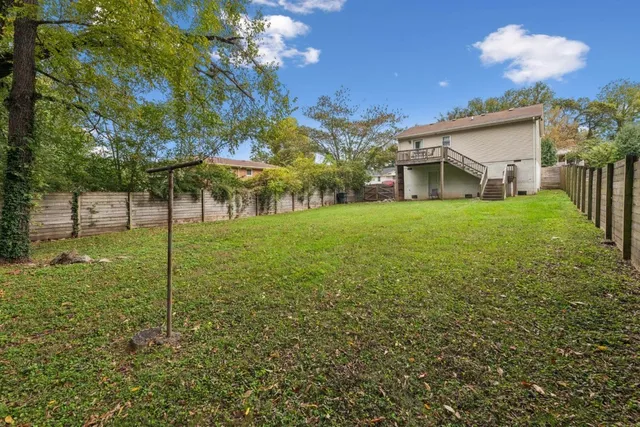 a view of a house with backyard and a tree