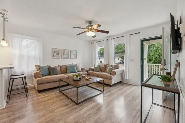 a living room with furniture dining area and a flat screen tv