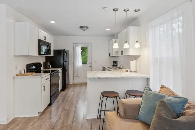 a kitchen with stainless steel appliances a sink a stove a refrigerator cabinets and a window