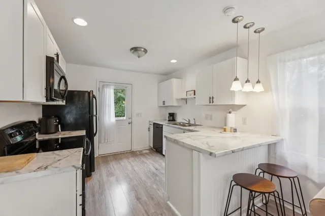a kitchen with a sink a stove a refrigerator and chairs