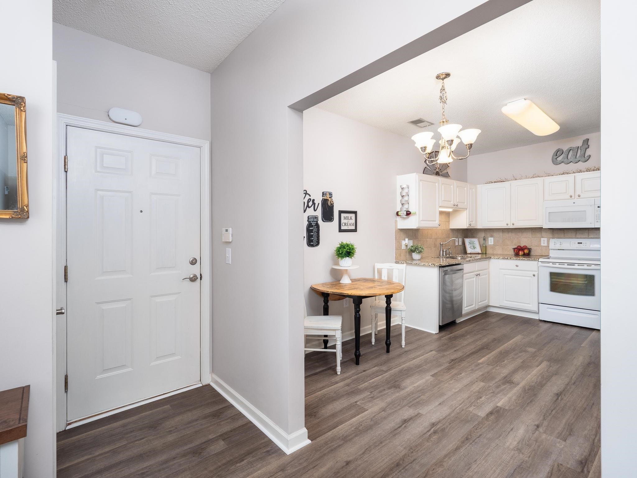 2511 Huntscroft Lane, Unit 201 Raleigh, NC 27617 - Photo 3 of 34 a open kitchen with cabinets wooden floor and stainless steel appliances
