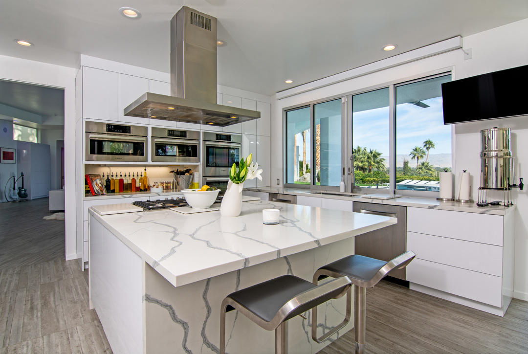 70288 Pecos Road Rancho Mirage, CA 92270 - Photo 28 of 76 a dining hall with stainless steel appliances kitchen island granite countertop a table chairs and a large window