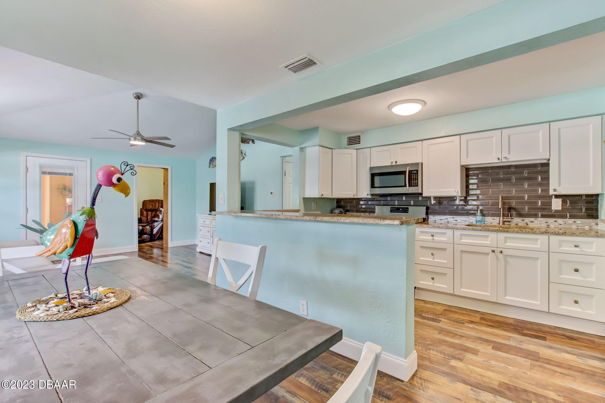 827 South Beach Street Daytona Beach, FL 32114 - Photo 14 of 40 a kitchen with stainless steel appliances granite countertop a sink dishwasher a stove a refrigerator oven with white cabinets and wooden floor