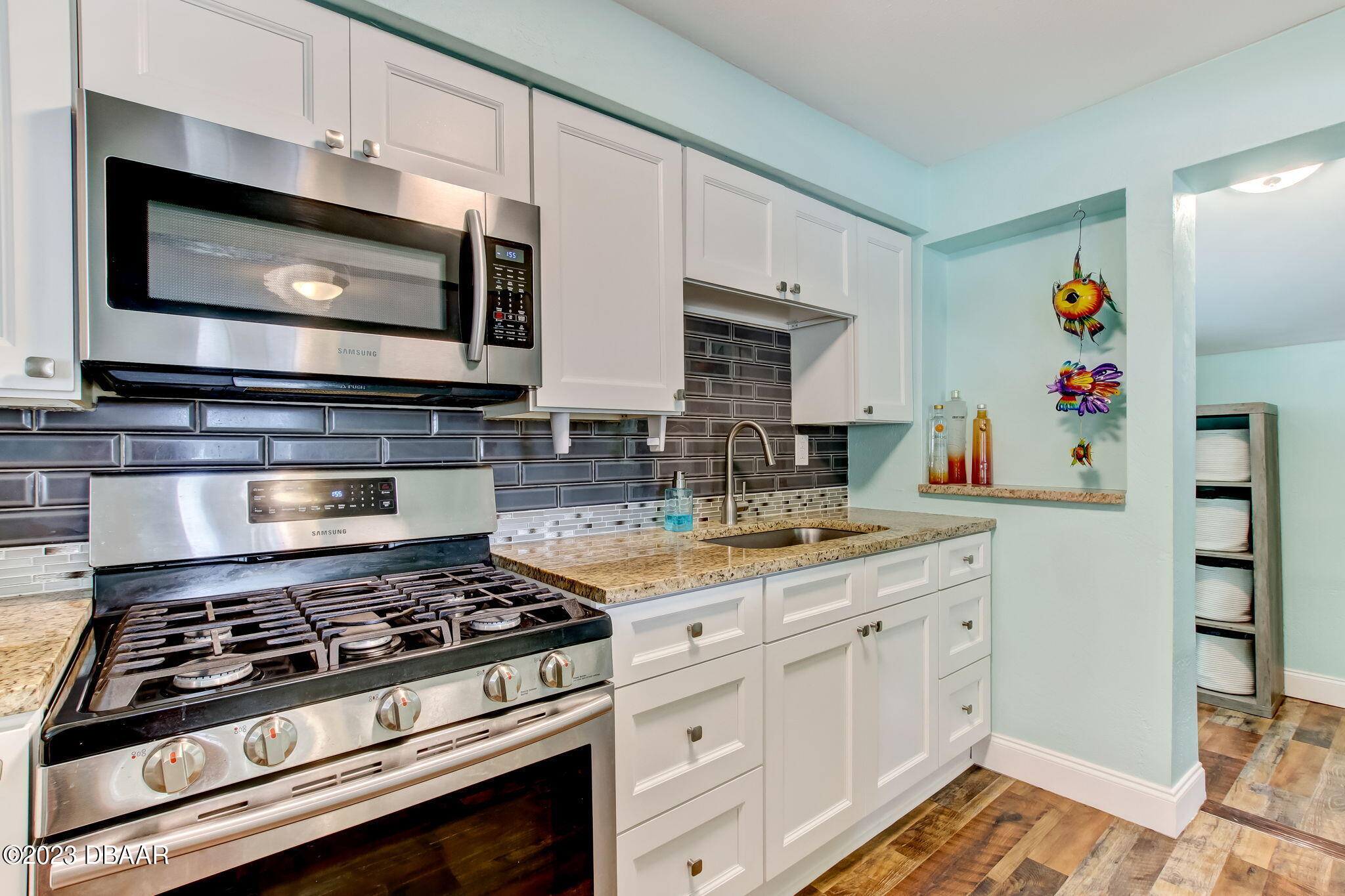 827 South Beach Street Daytona Beach, FL 32114 - Photo 16 of 40 a kitchen with stainless steel appliances a stove a microwave and cabinets