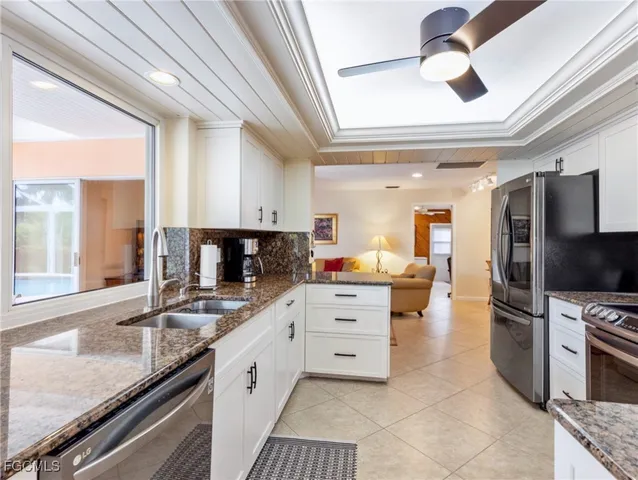 a kitchen with granite countertop a sink appliances and cabinets