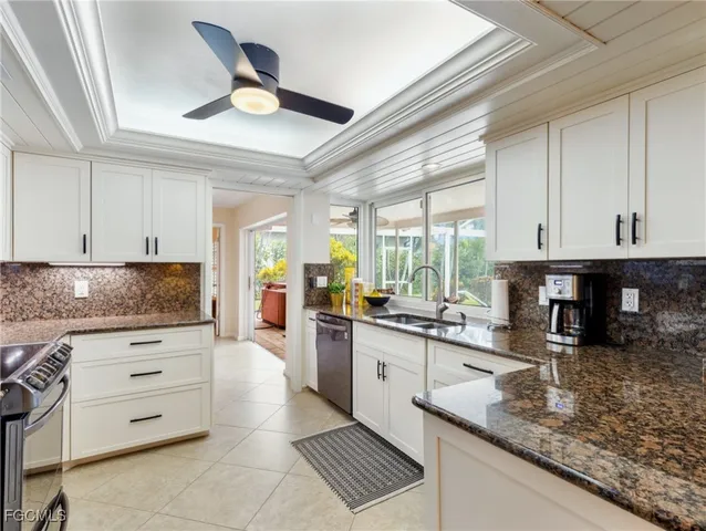 a kitchen with granite countertop a stove sink and cabinets