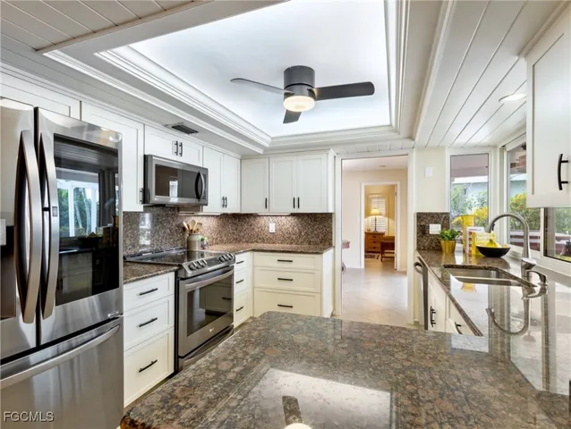 a kitchen with stainless steel appliances granite countertop a stove top oven a sink a dining table and chairs