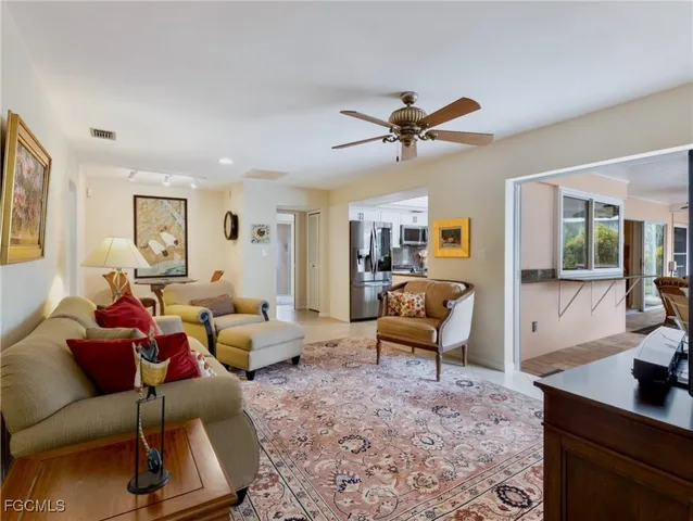 a living room with furniture a lamp wooden floor and a rug