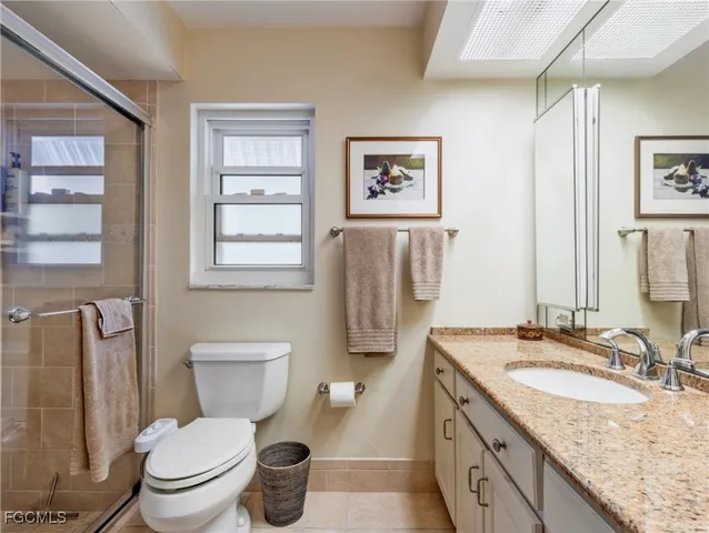 a bathroom with a granite countertop toilet sink and mirror
